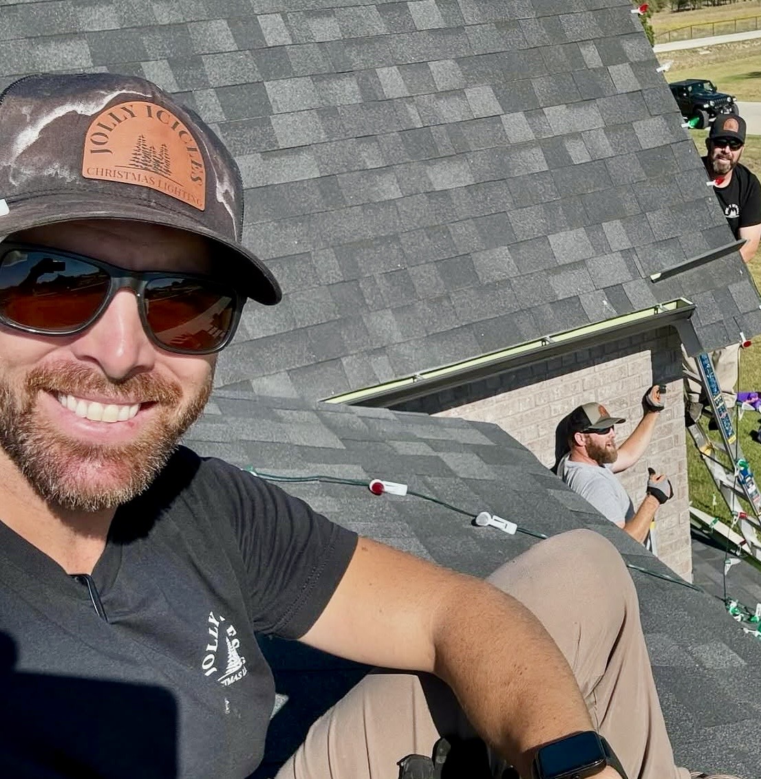 Jolly Icicles crew installing roofline lights on a brick home