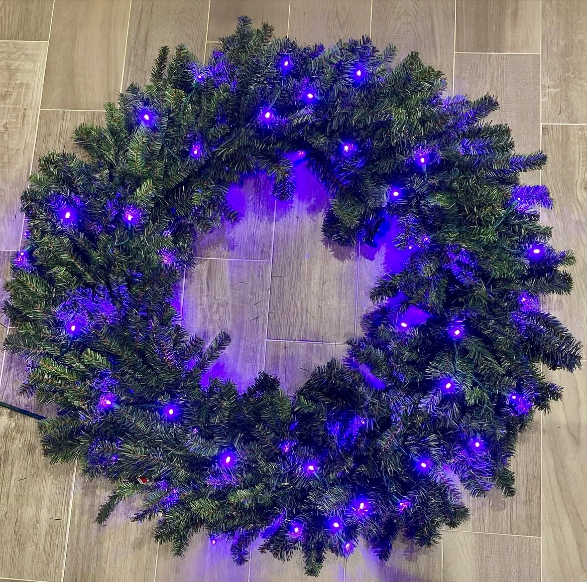 Lit Christmas wreath with purple bulbs